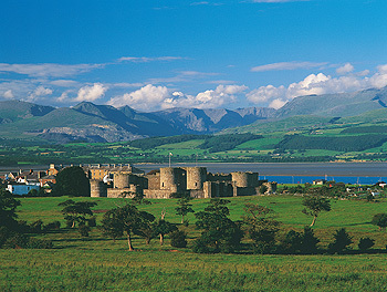 Beaumaris Castle with snowdonia mountains.jpg